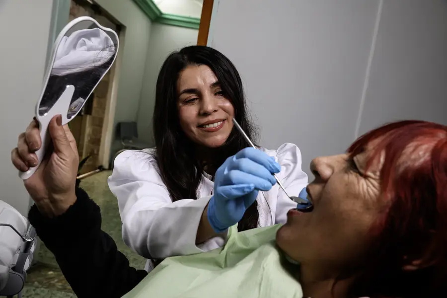 Paciente mirando su sonrisa en un espejo durante la consulta